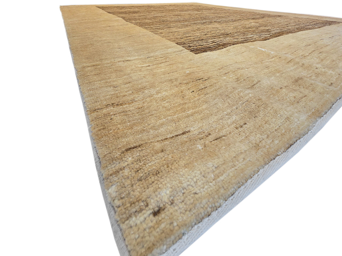 Beige area rug corner view with dark brown inset panel and textured surface