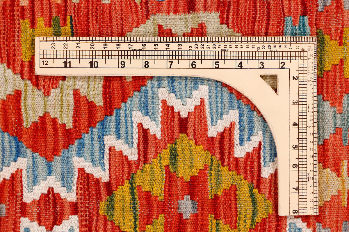 Kilim rug with red, blue, cream, and yellow geometric pattern; border with fringed edge.
