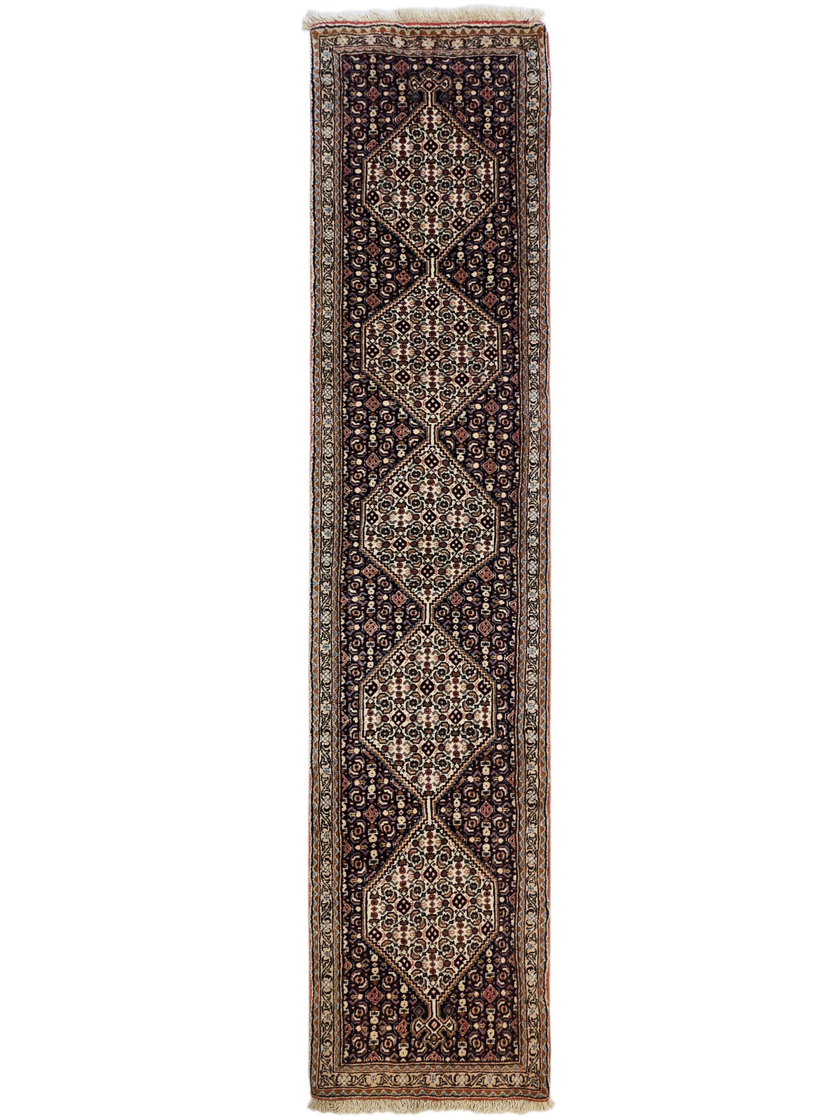 Vertical view of dark geometric runner rug with diamond medallions and cream fringe