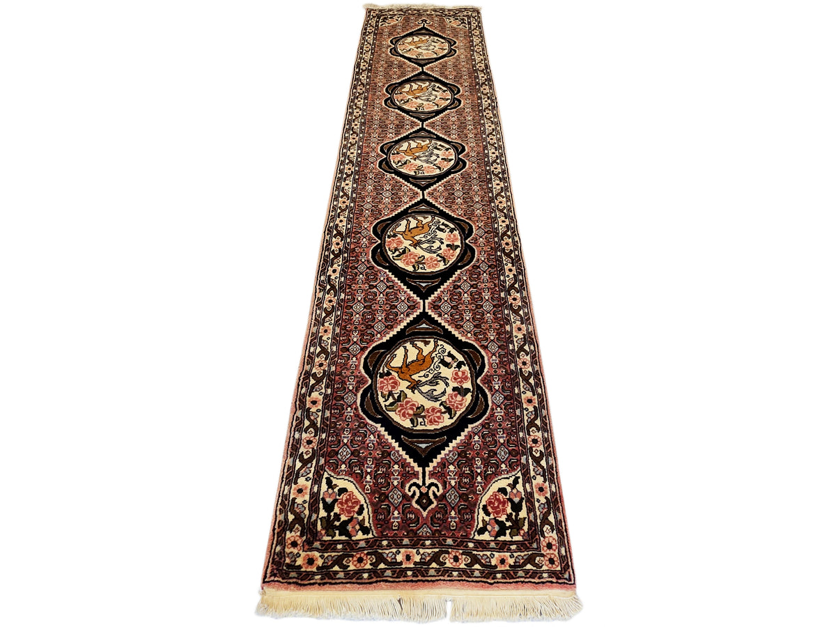 Runner rug with tall central medallion row, maroon border, and cream fringe edge