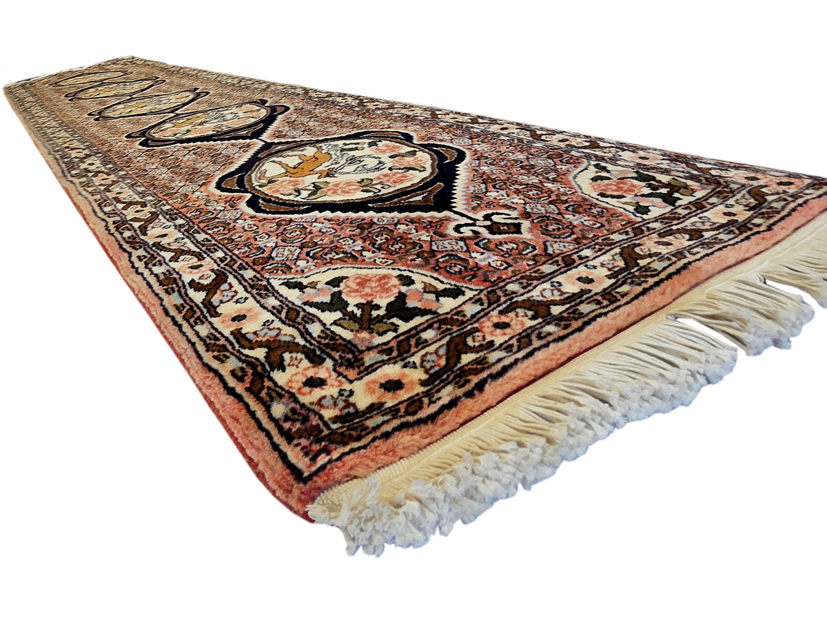 Rectangular runner rug with maroon field, cream medallions, and long cream fringe