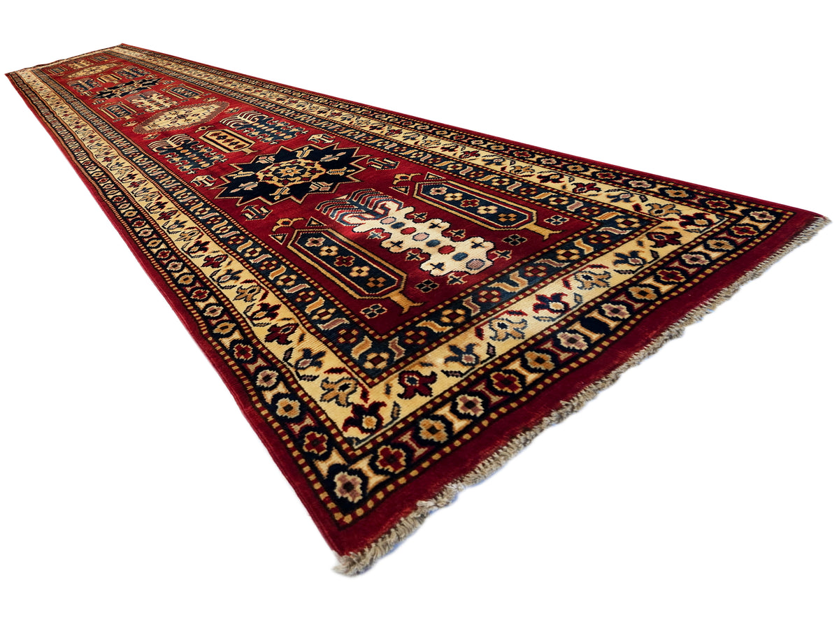 Diagonal rectangular Sherwan rug, maroon red with cream and navy geometric ornament, fringed.