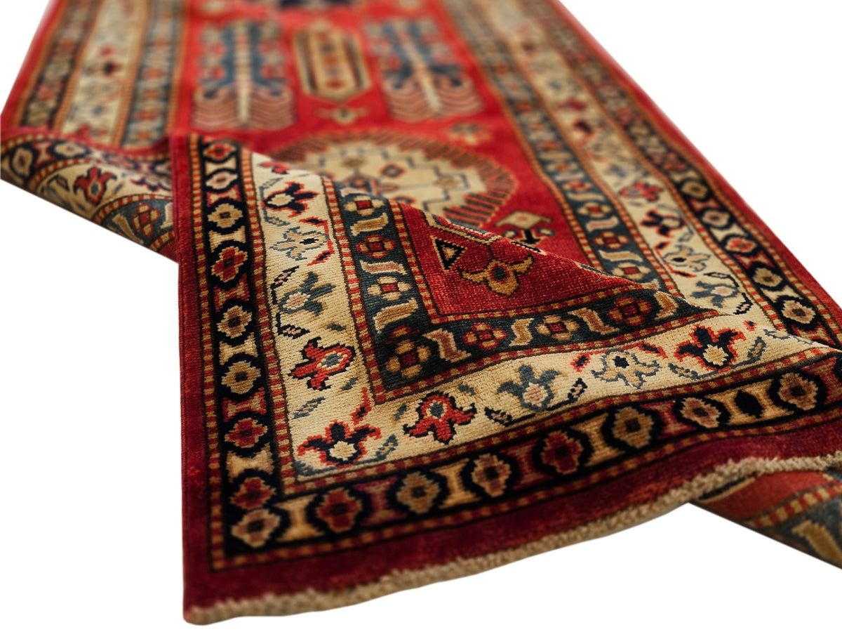 Close-up of Sherwan rug field with red and cream medallion and navy accents.
