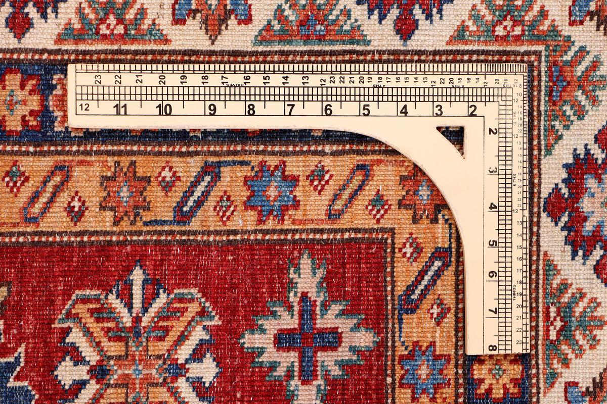 Red Kazak rug edge with measuring ruler and decorative border, 198x155 cm