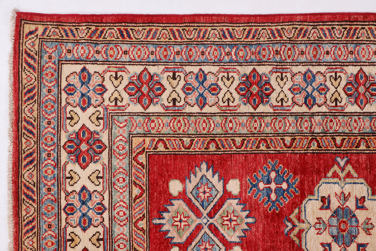 Red rug with blue and cream geometric medallions and detailed border pattern