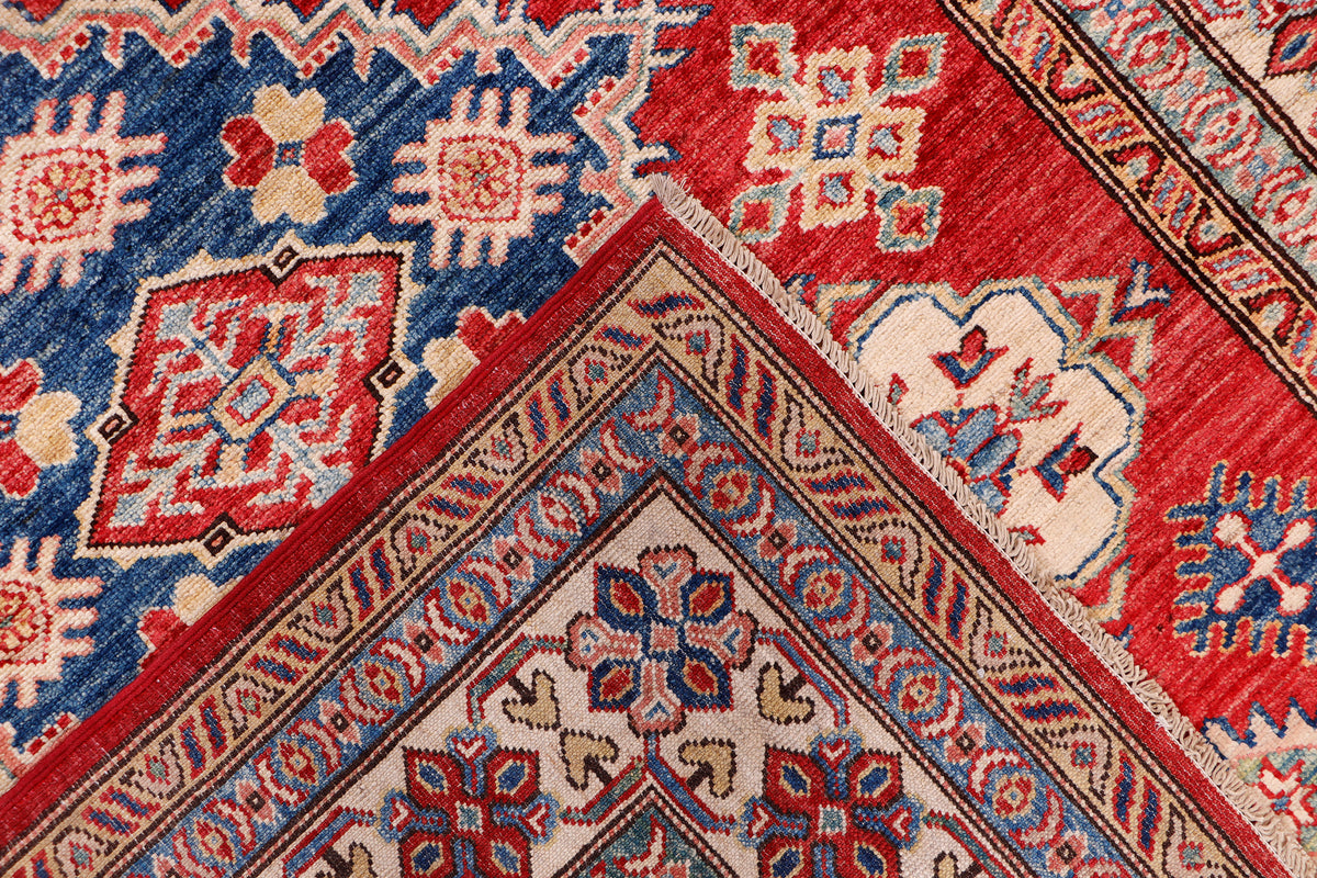 Blue and red patterned rug corner with ornate border and star-like motifs