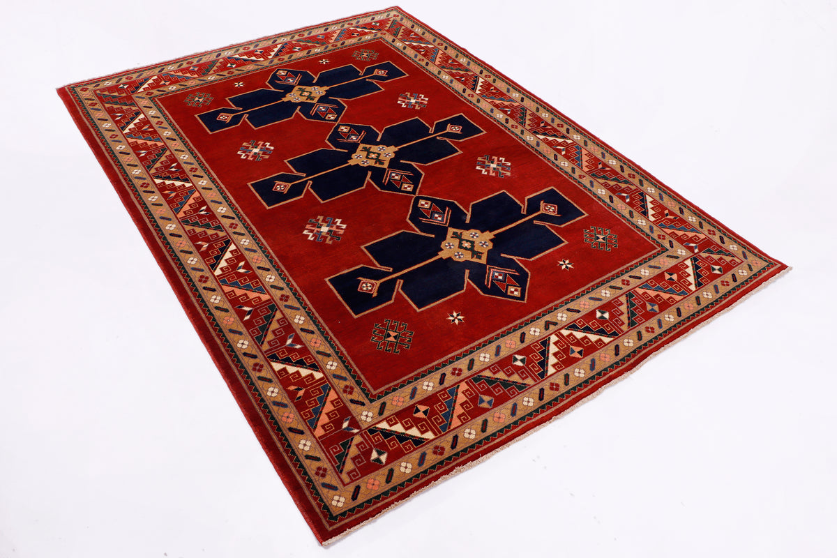 Red rug with navy and cream medallion center and ornate geometric border