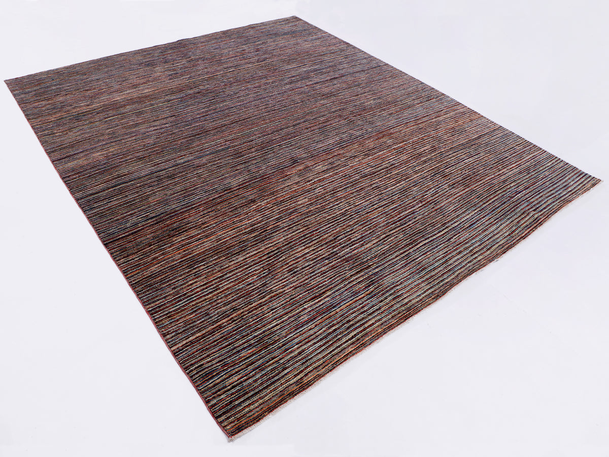Brown and blue striped rug shown diagonally, textured flat-woven surface.