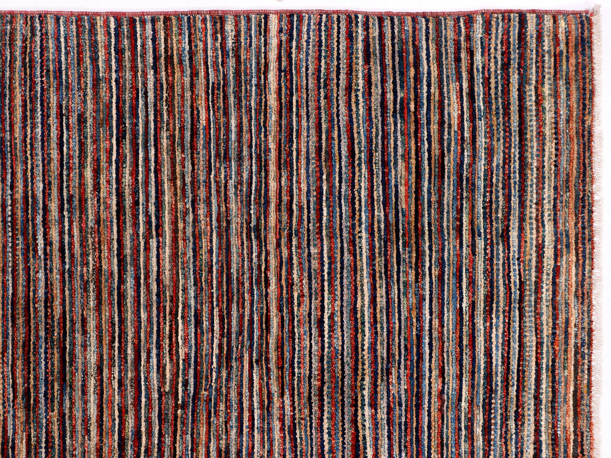 Multicolor vertical striped rug close-up with red, blue, and cream lines.