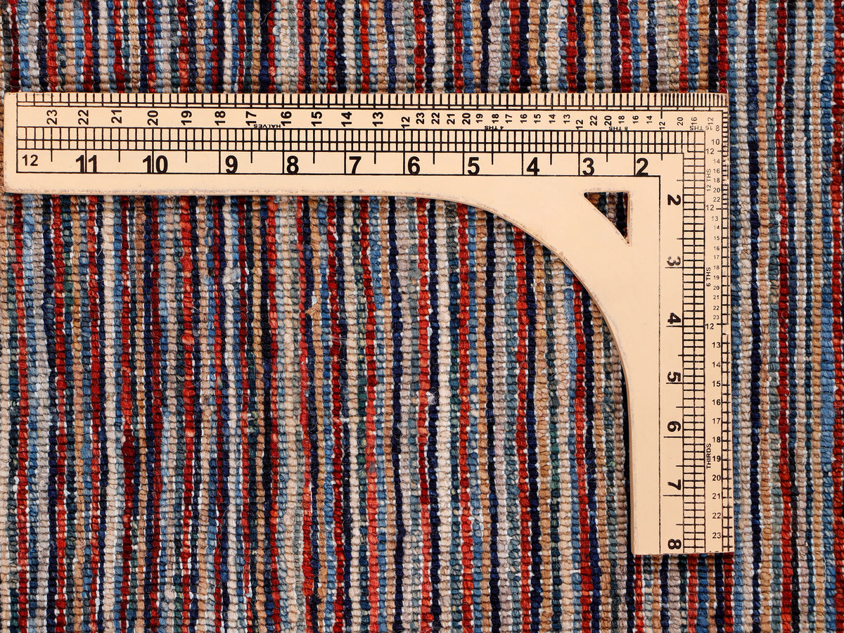 Multicolor striped rug with measuring tape showing scale across the surface.