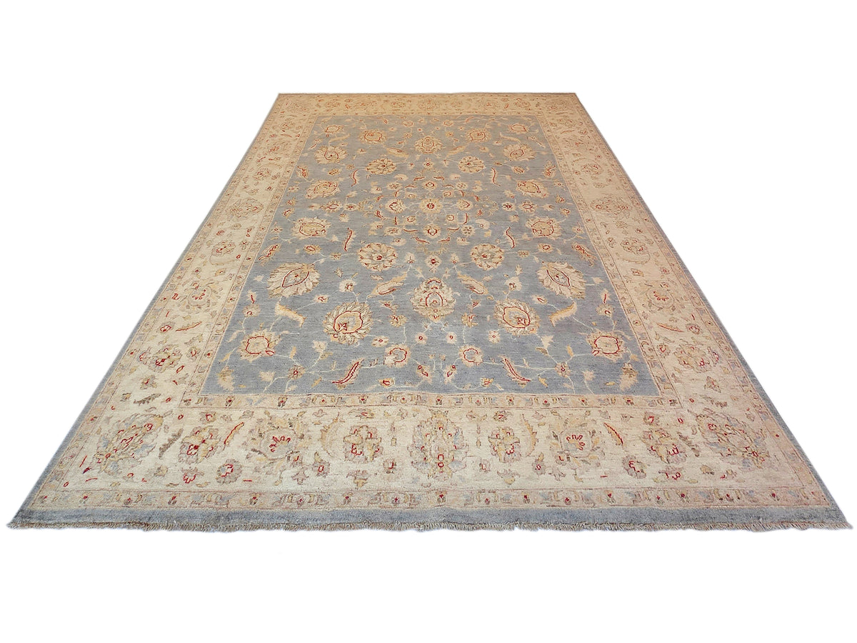 Large area rug with blue center medallion pattern on beige border, fringed ends