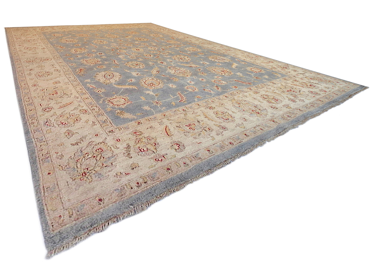 Large area rug with blue floral field, beige ornamental border, textured short fringe
