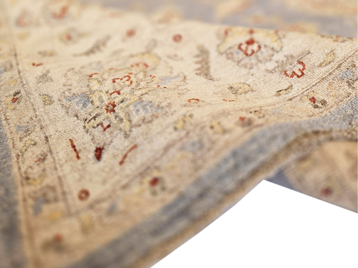 Rug close-up: beige ground with scattered red and blue floral accents, tufted texture