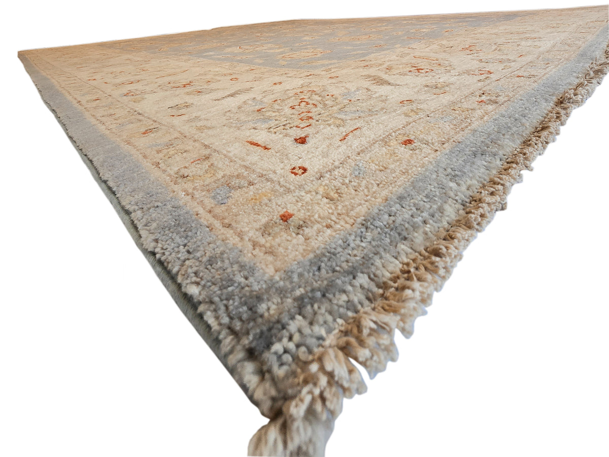 Rug corner with beige center, light blue edging and dense short fringe tassels