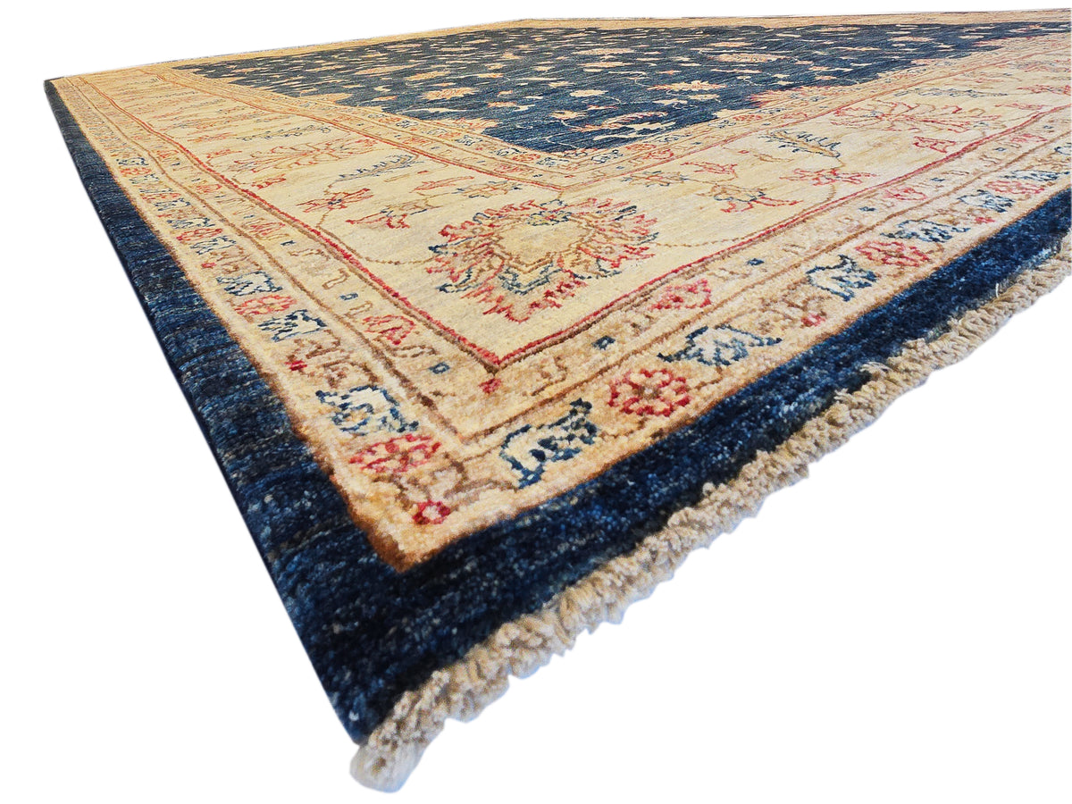 Blue, cream, and red patterned rug with central floral medallion and dark edge fringe.