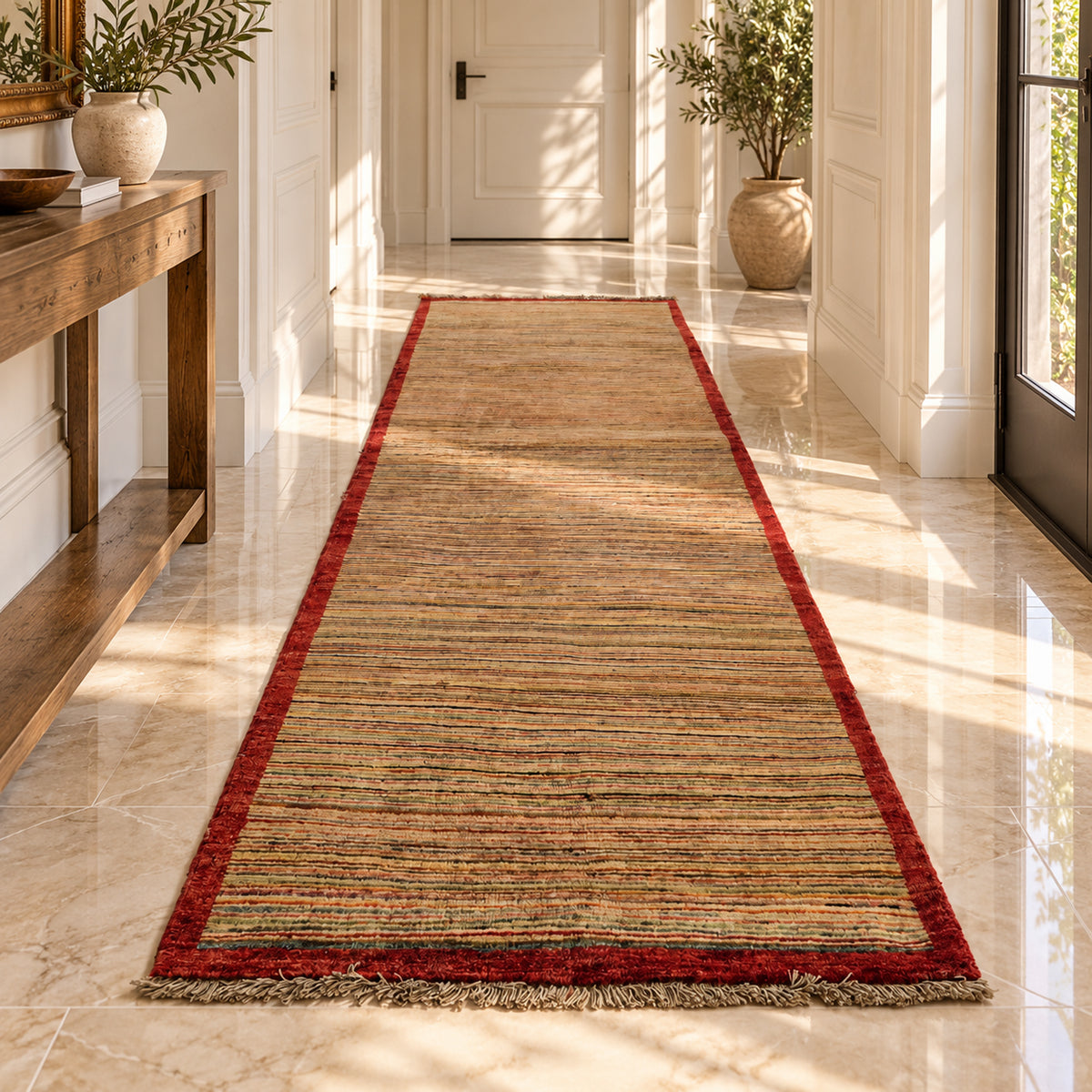 Gabbeh runner rug on the floor, brown striped design with red border.