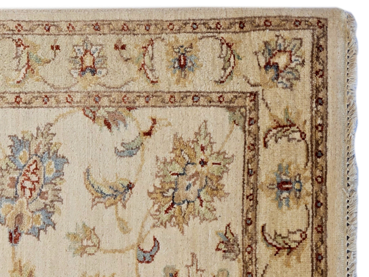 Close-up of beige floral rug panel with intricate border and multicolor accents