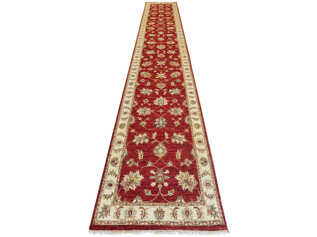 Red runner rug with cream patterned border and floral medallion motifs, 489x80 cm