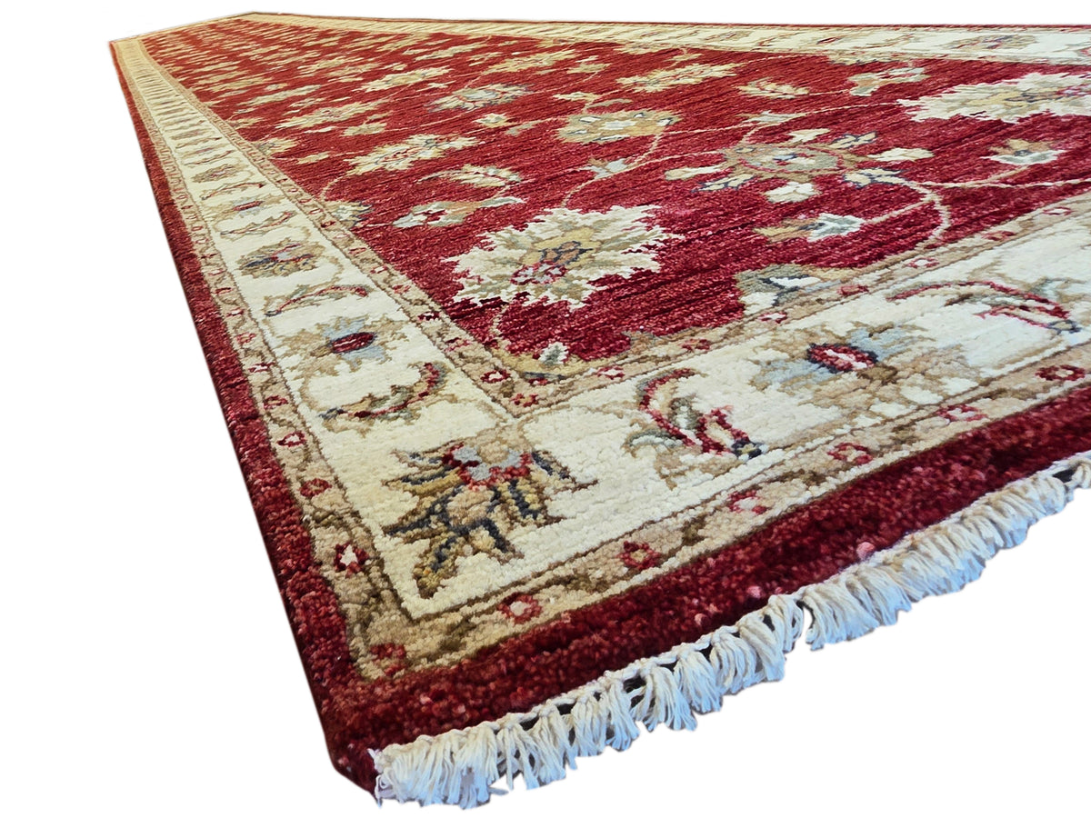 Red runner rug with cream border and floral motifs, blue fringe trim, 489x80 cm