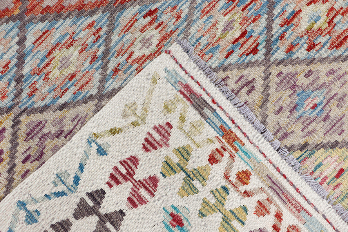 Beige kilim diamond rug corner close-up with multicolor geometric pattern and trim