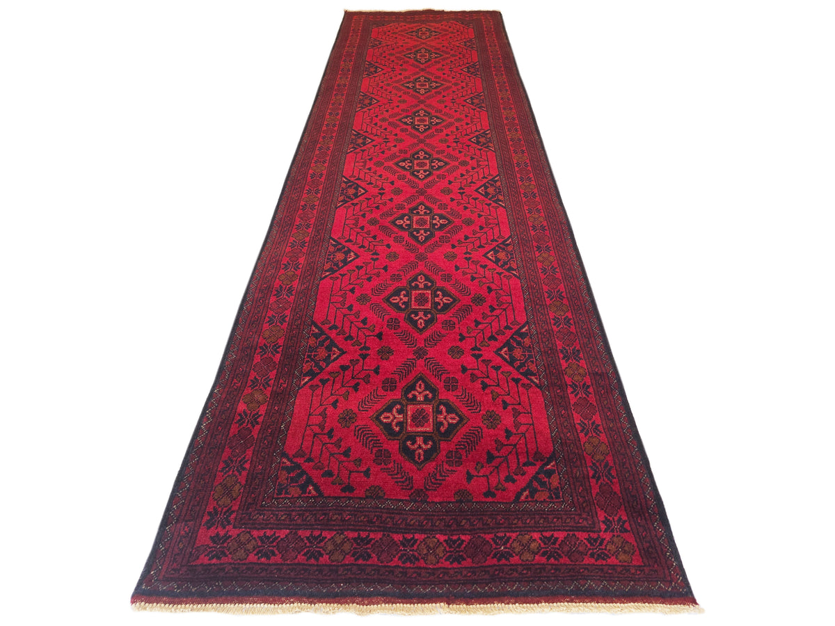 Red rug runner with central diamond medallion pattern and fringed trim